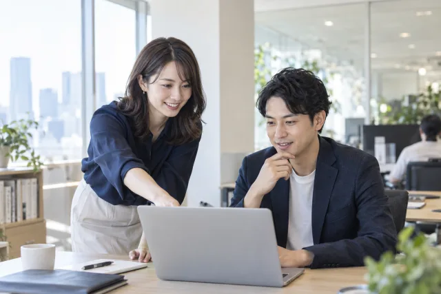 IT colleagues reviewing a laptop together